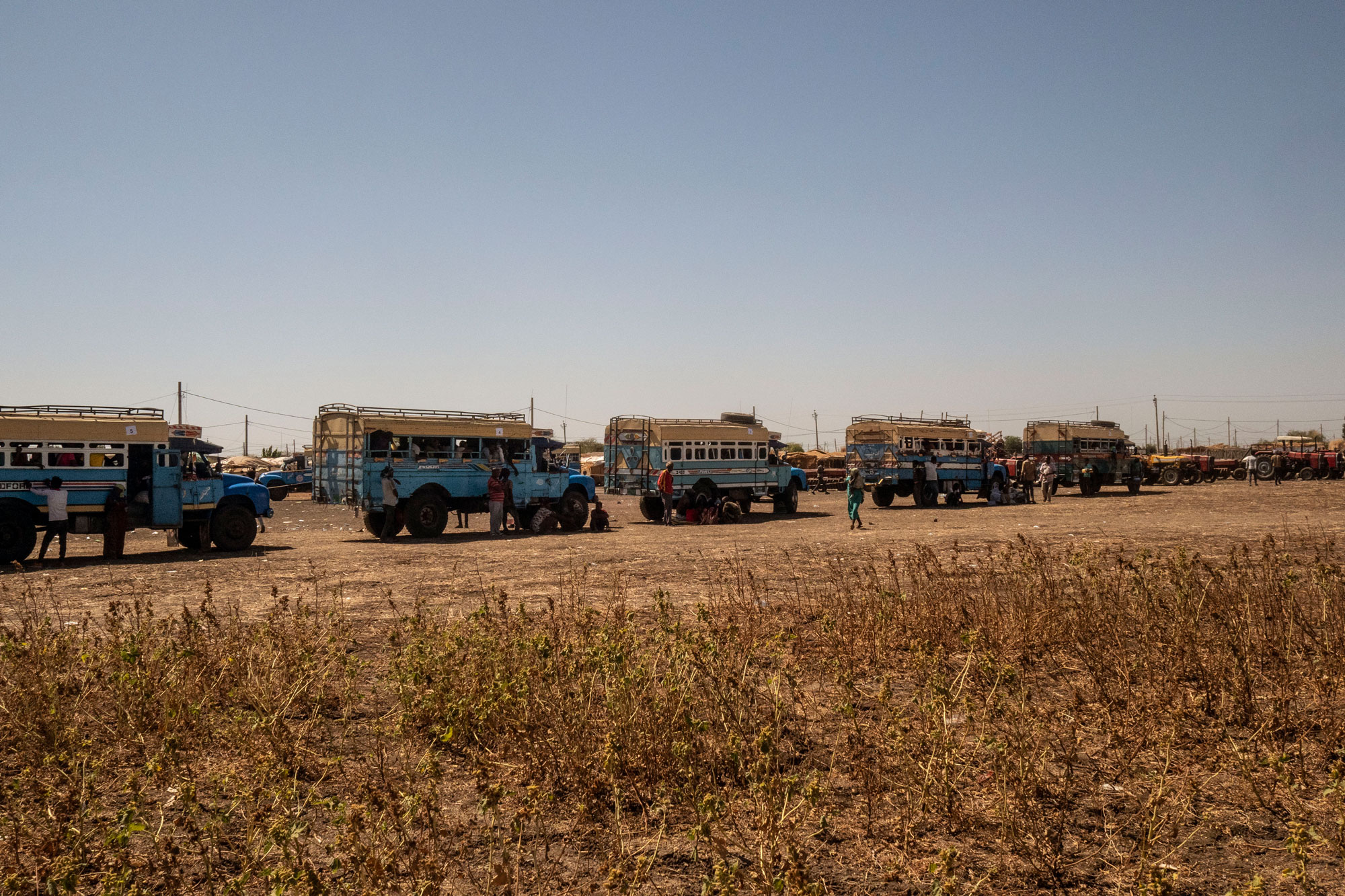 A caravan of buses prepare for the hours-long journey to Um Rakuba refugee camp. 
