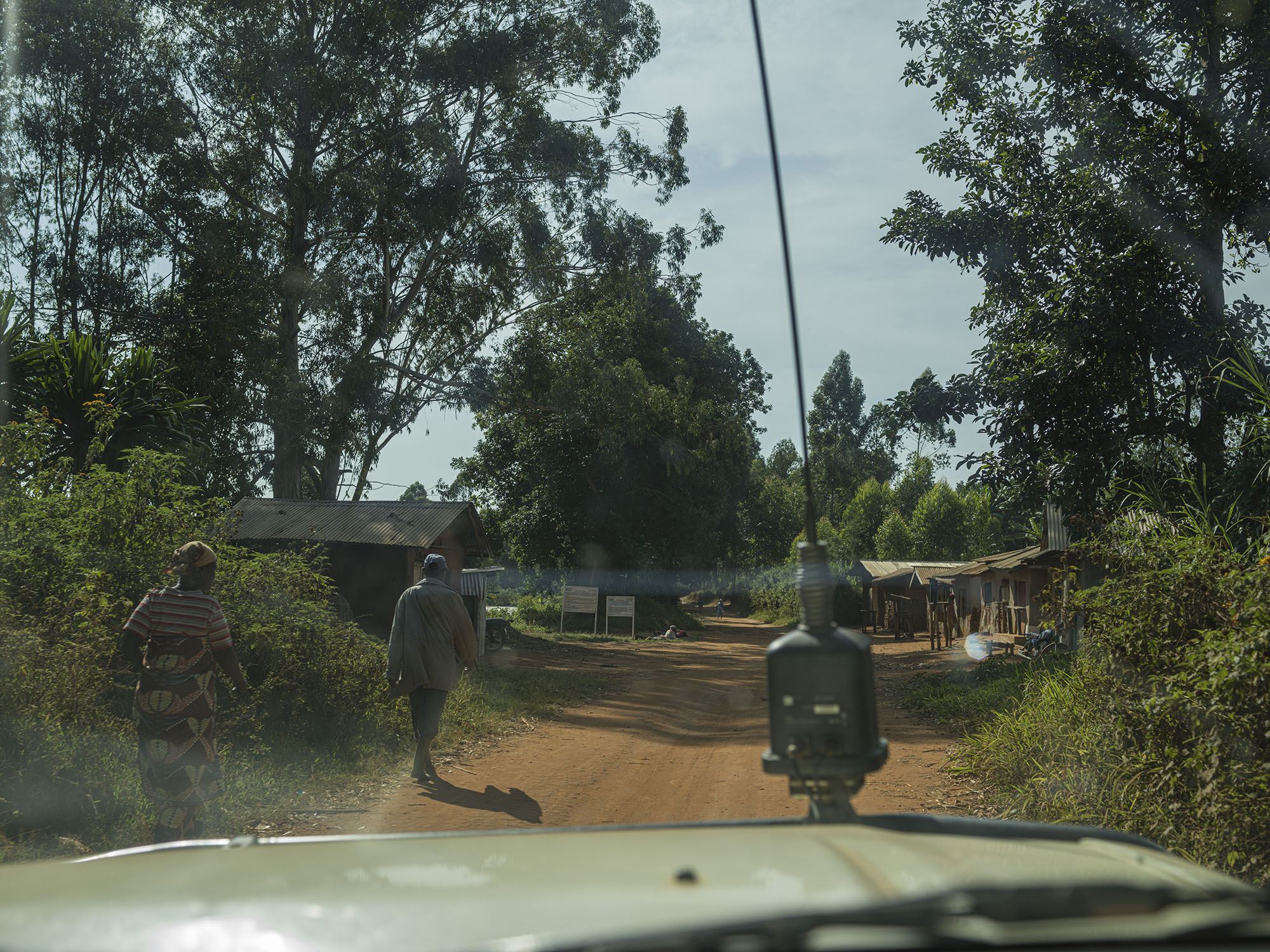 People walk along the road to Drodro, as seen from inside an MSF vehicle. 