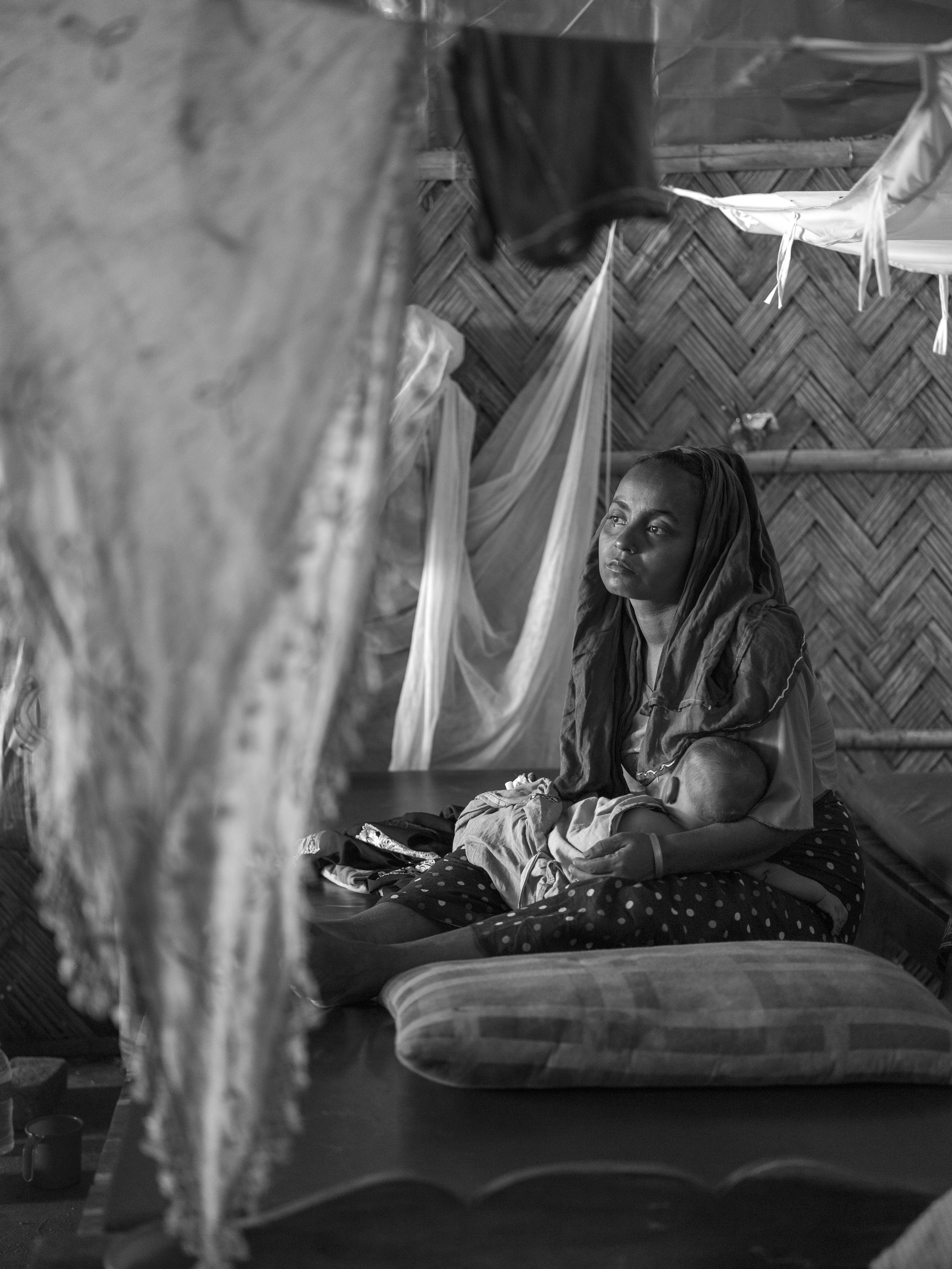Yasmin, 21 ans, réfugiée Rohingya, et son fils Mohamed, 5 ans, souffrant d'une forte fièvre, sont assis sur un lit à la clinique MSF de Kutupalong. Bangladesh, 2017 