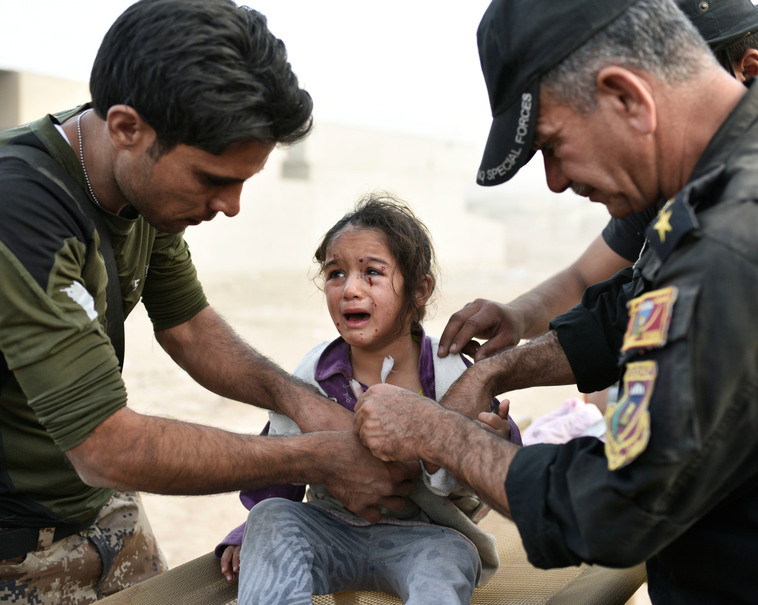 Des civils blessés sont soignés par les forces irakiennes après une attaque au mortier et à la voiture piégée par l’Etat islamique.