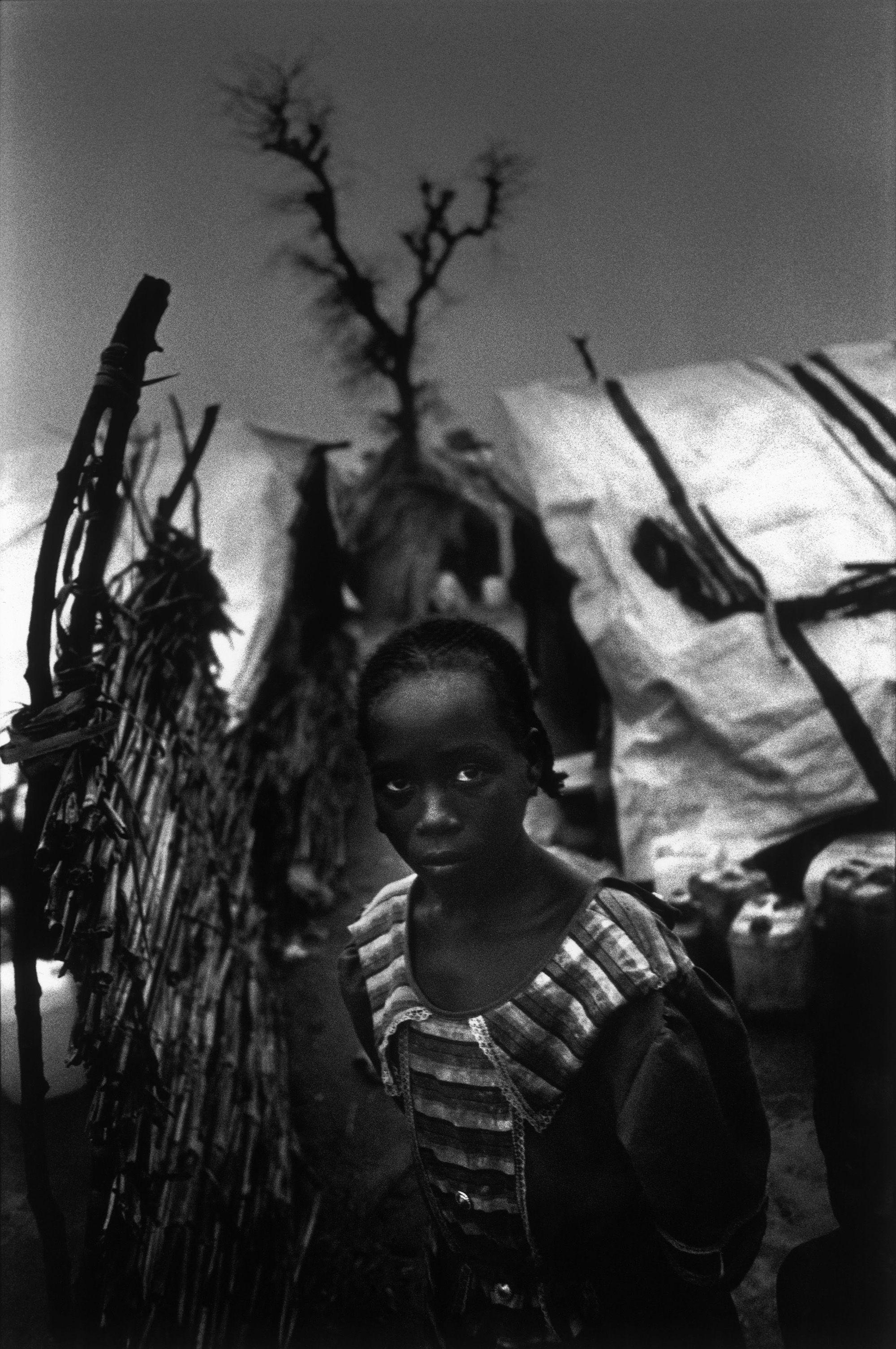 Süd-Darfur, Sudan, 2004. Mädchen in einem Vertriebenenlager in Zelingei während eines Gewitters. 