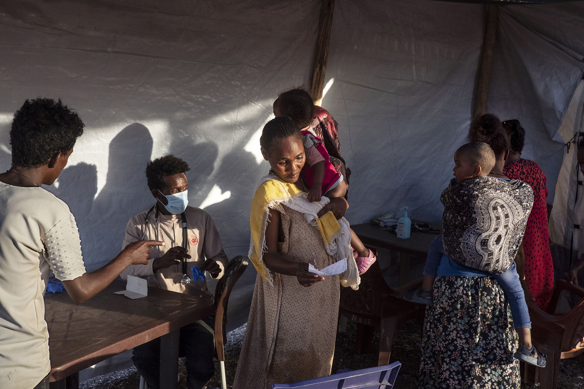 People receive medical care at an MSF clinic inside Al-Shabat transit center. 