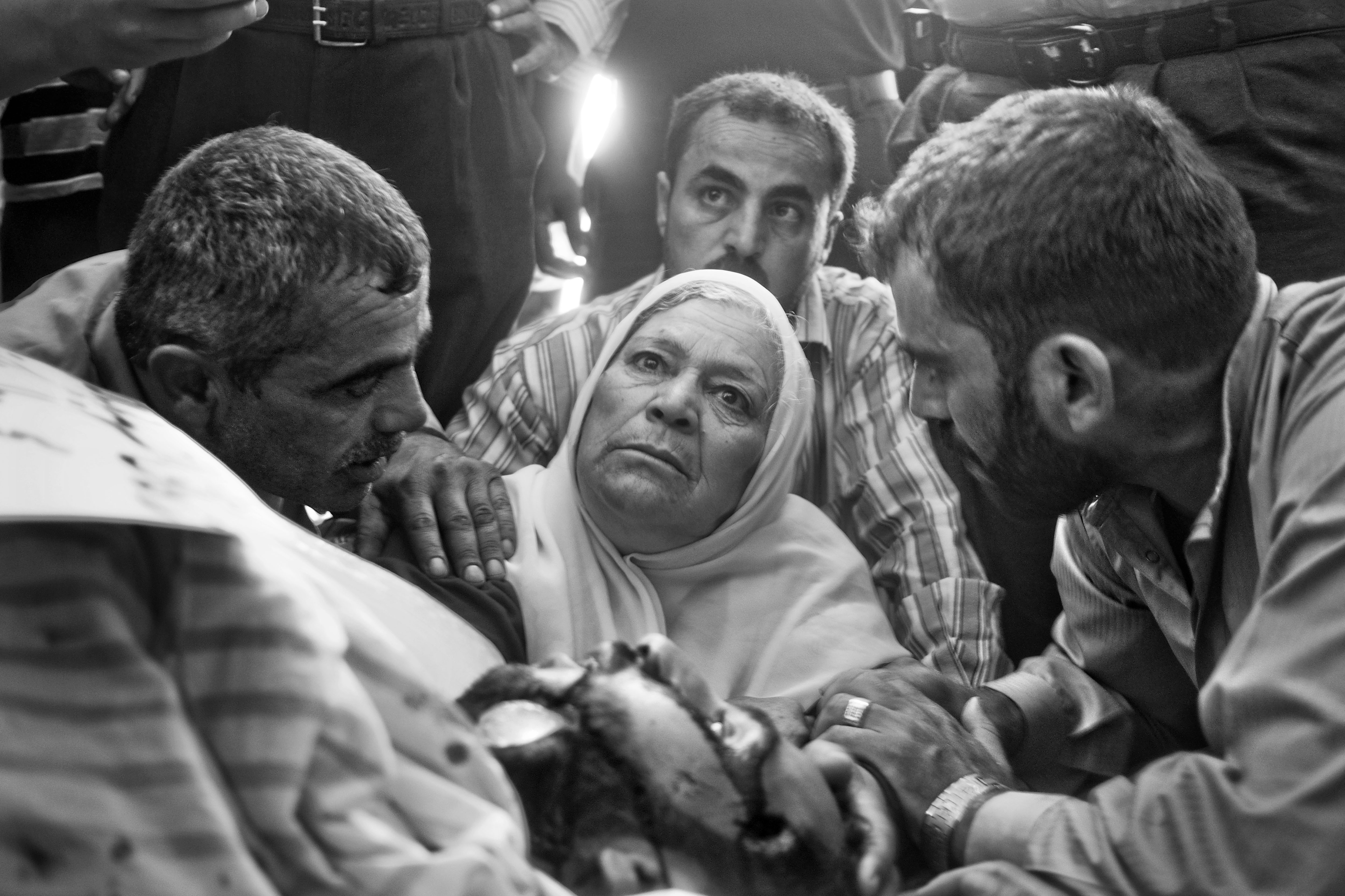 Fatma Al-Krama est entourée de membres de sa famille alors qu'elle est assise à côté du corps de son fils décédé.