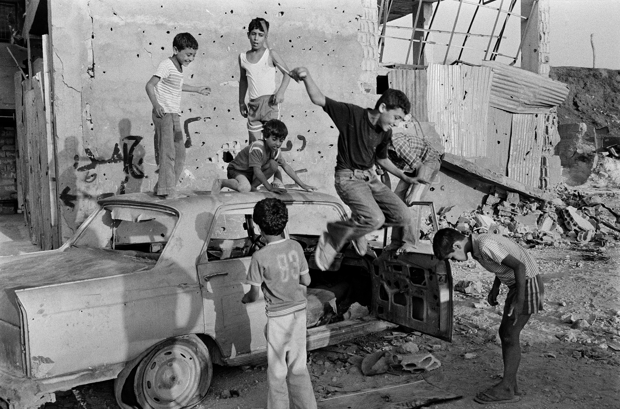 Beyrouth, Liban, 1983. Des enfants jouent dans les véhicules accidentés près du camp de Sabra et Chantila.