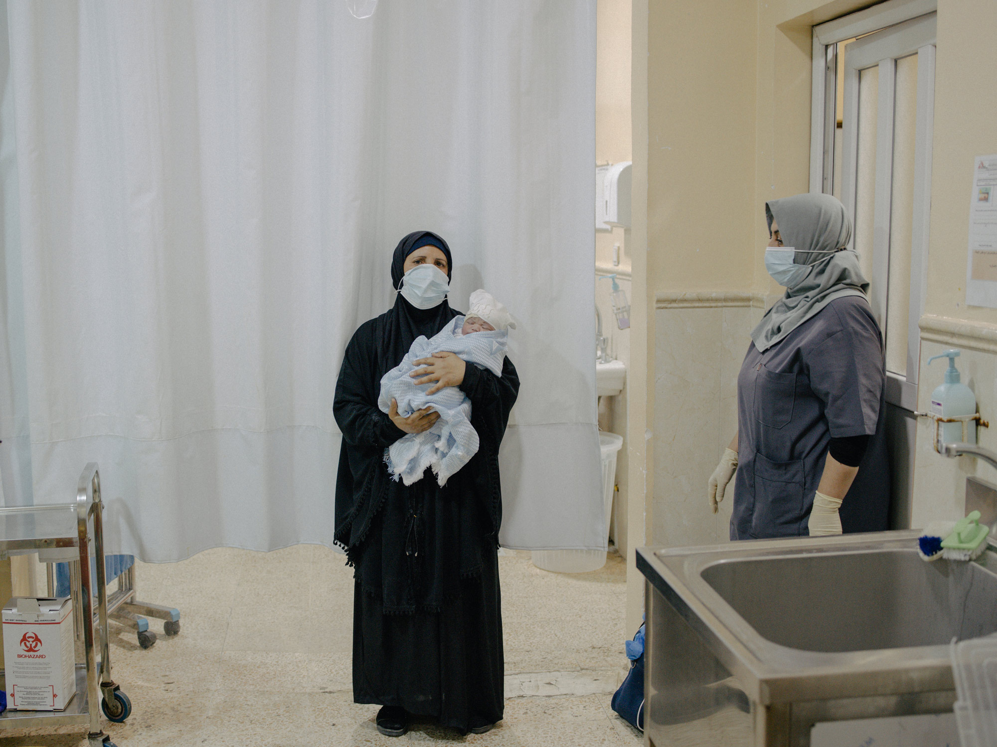 2021年9月15日，伊拉克摩蘇爾，在MSF納布盧斯醫院的產科病房裡，一名婦女抱著她的孫子。