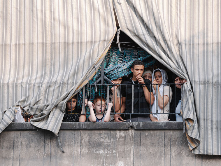 Eine Familie schaut von ihrem Balkon auf die Stadt. In dieser Phase des Konflikts erschüttern intensive Kämpfe Aleppo. 