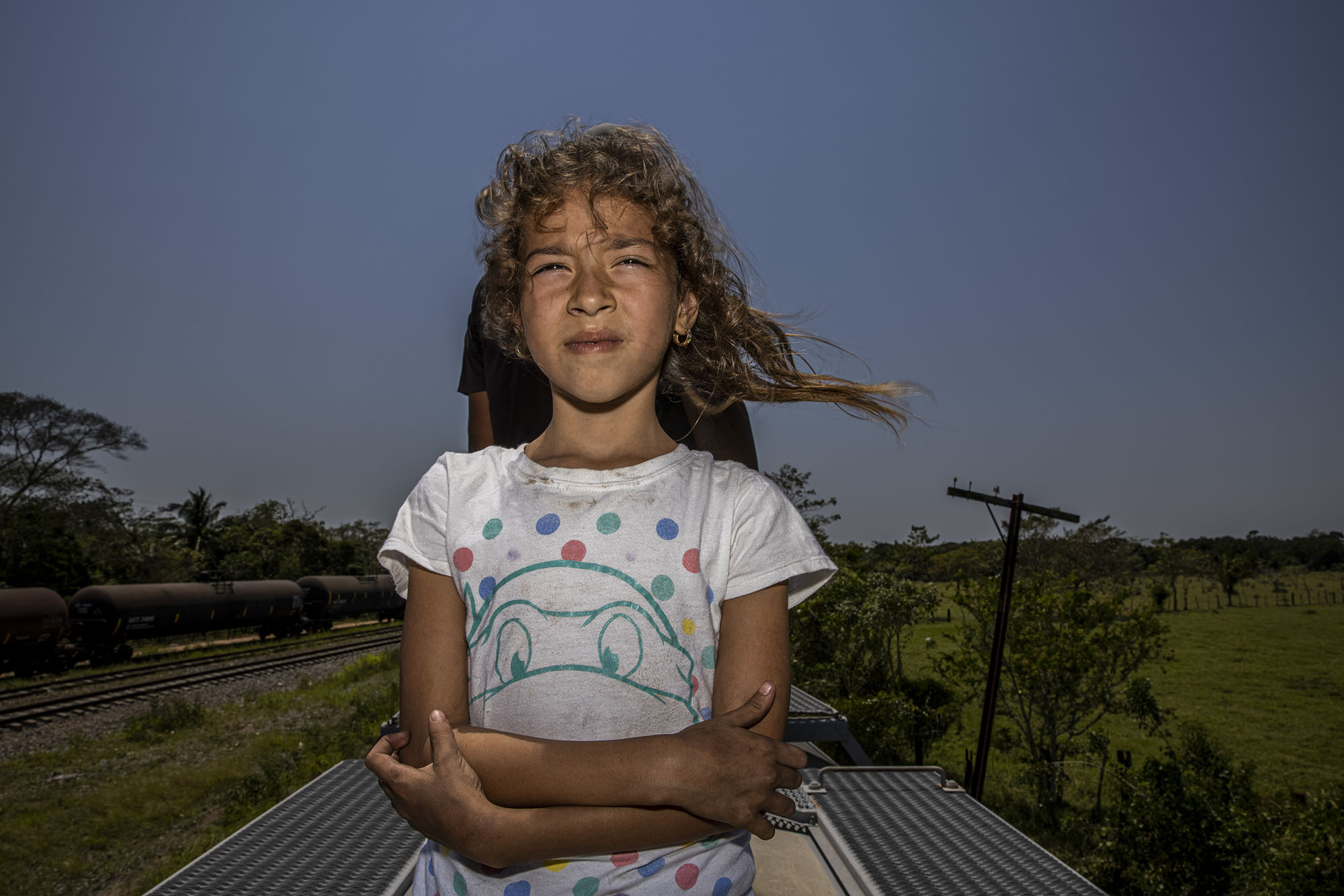 墨西哥，韋拉克魯斯州的修格拉斯，2021年3月23日。7歲的卡倫．約瑟琳．雷耶斯（Karen Yoselyn Reyes）與她30歲的母親和2歲的妹妹，12天前從宏都拉斯的約倫（Yoro）出發。她們從恰帕斯州的塔帕丘拉（Tapachula) 一路走到韋拉克魯斯州的夸察夸爾科斯鎮（Coatzacoalcos）。卡倫最擔心的是帶著妹妹的母親無法登上火車。（攝影／Yael Martínez／Magnum Photos）
